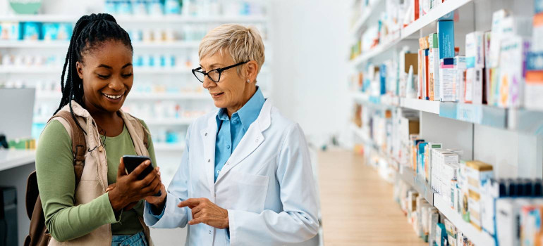 Eine junge Frau lässt sich in einer Apotheke beraten