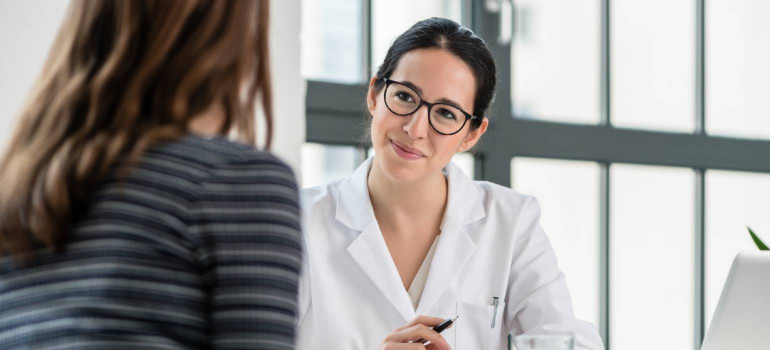 Eine Frau spricht mit einer Ärztin über Patientenrechte