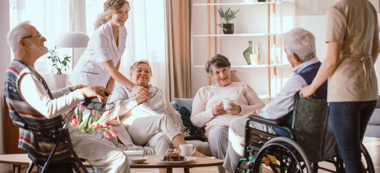 Eine Gruppe pflegebedürftiger Menschen in ihrem gemeinsamen Wohnzimmer