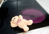 Ein Teddybär liegt auf einer eingeschalteten Herdplatte