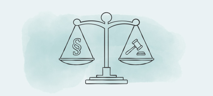 Eine Waage mit einem Paragrafen-Symbol und einem Richterhammer