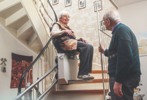 Eine ältere Damen fährt mit einem Sitzlift